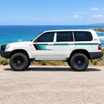 LandCruiser with teal stripes beside the ocean