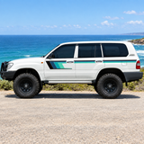 LandCruiser with teal stripes beside the ocean