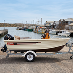 The Quintrex boat in a fishing town harbour with moored fishing boats and a jetty behind