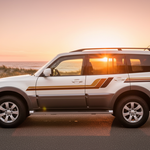 Vehicle with gold, copper and brown stripes in an Australian coastal sunset setting
